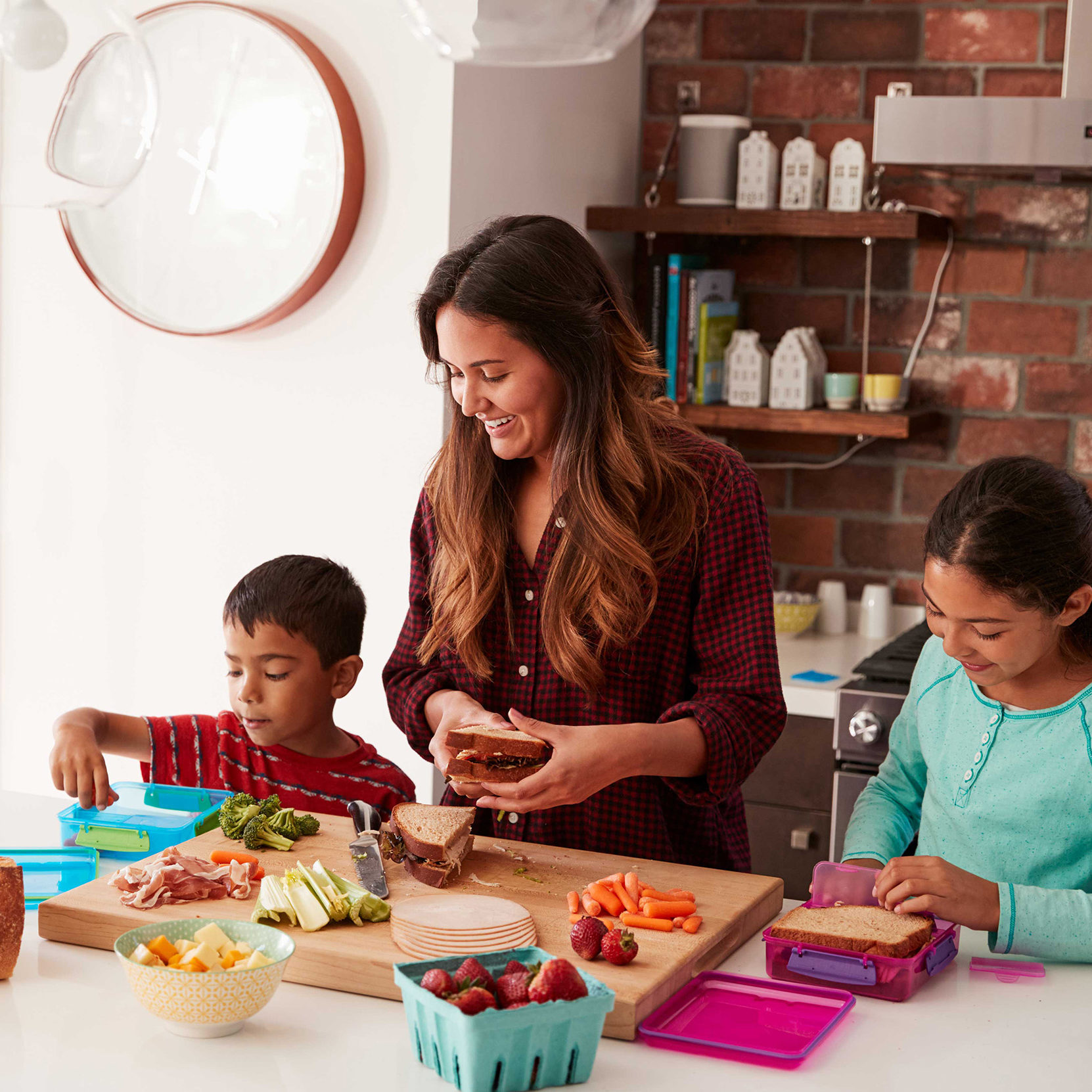 woman preparing lunch with two children