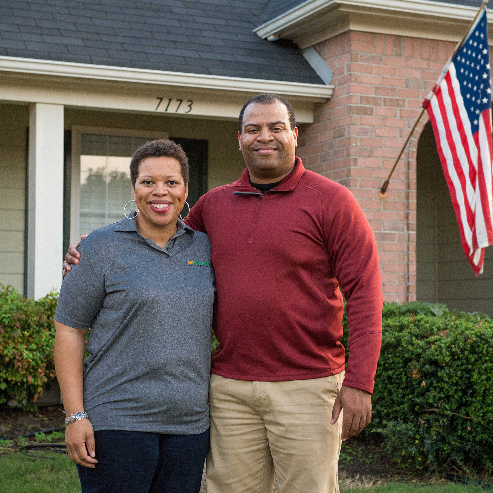 couple standing in front of their home 