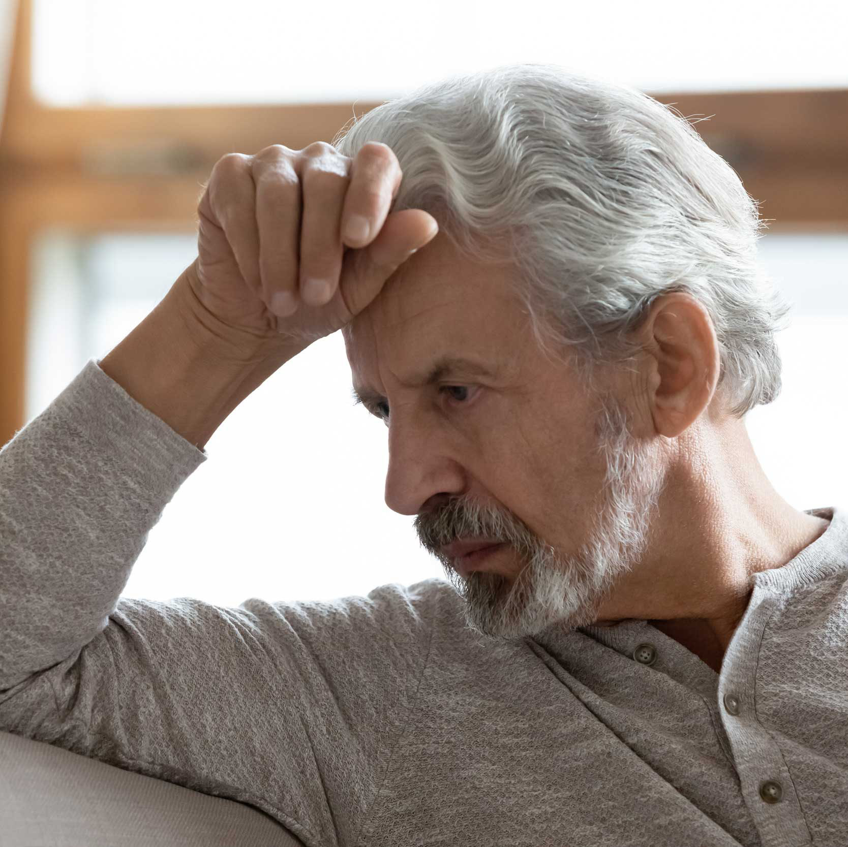 man with head resting on hand looking concerned
