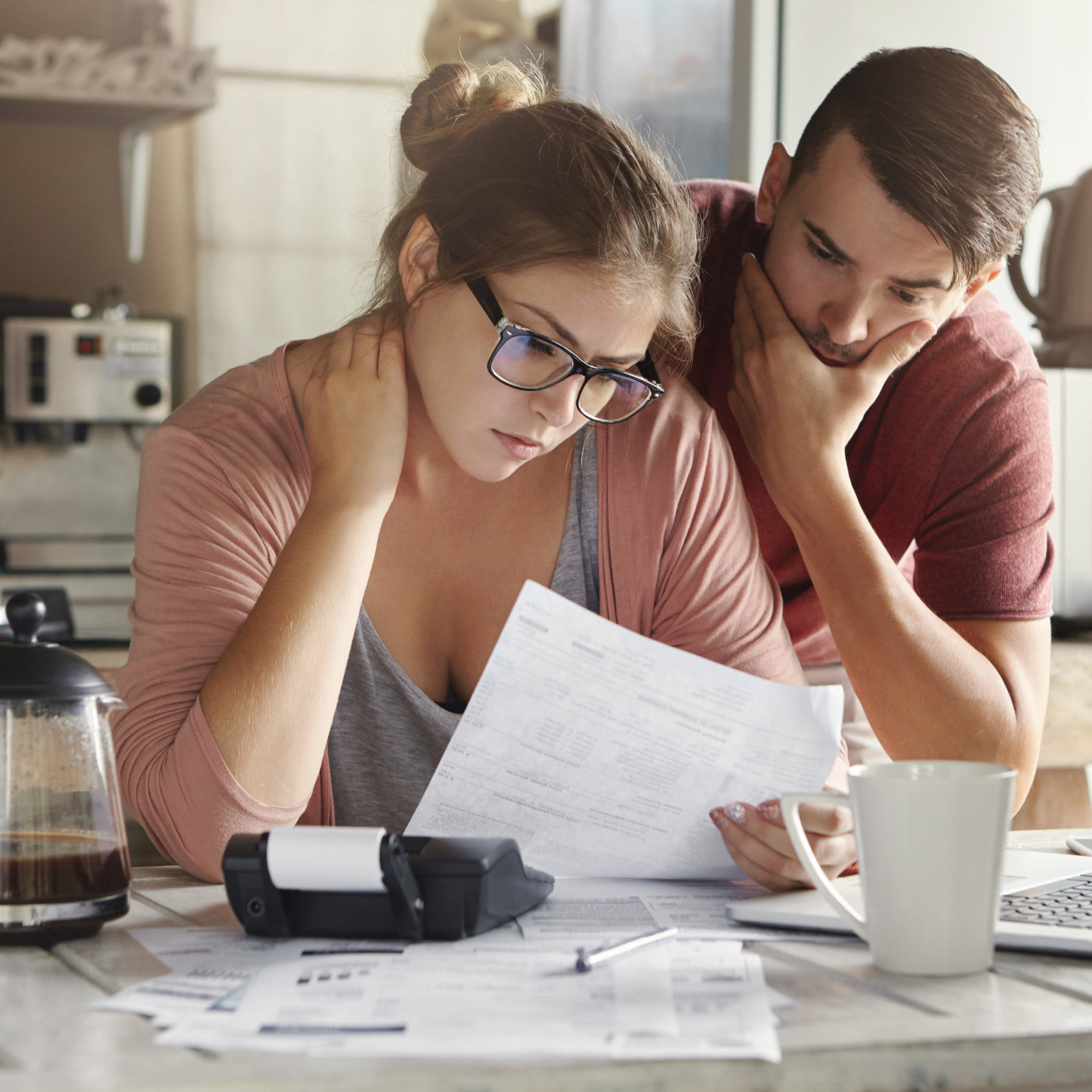 couple with concerned faces looking at a budget 