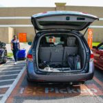 Picture of Walmart employee delivering groceries to a parked van