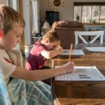 Picture of two young boys doing homework at a dining room table