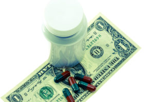 Picture of pills on top of a dollar bill