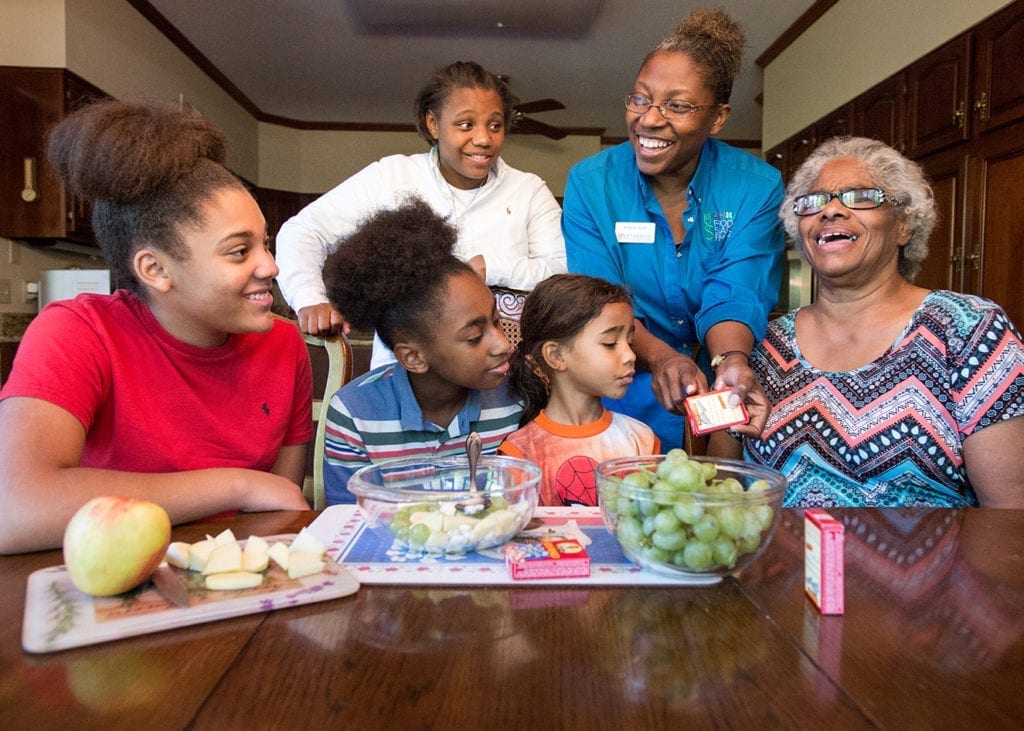 An Extension agent shows a family how to prepare healthy snacks